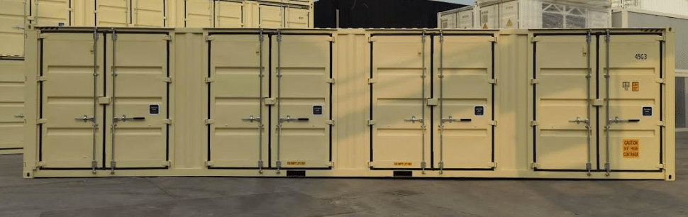 Yellow quad door shipping containers stacked in a yard, showcasing secure storage solutions.