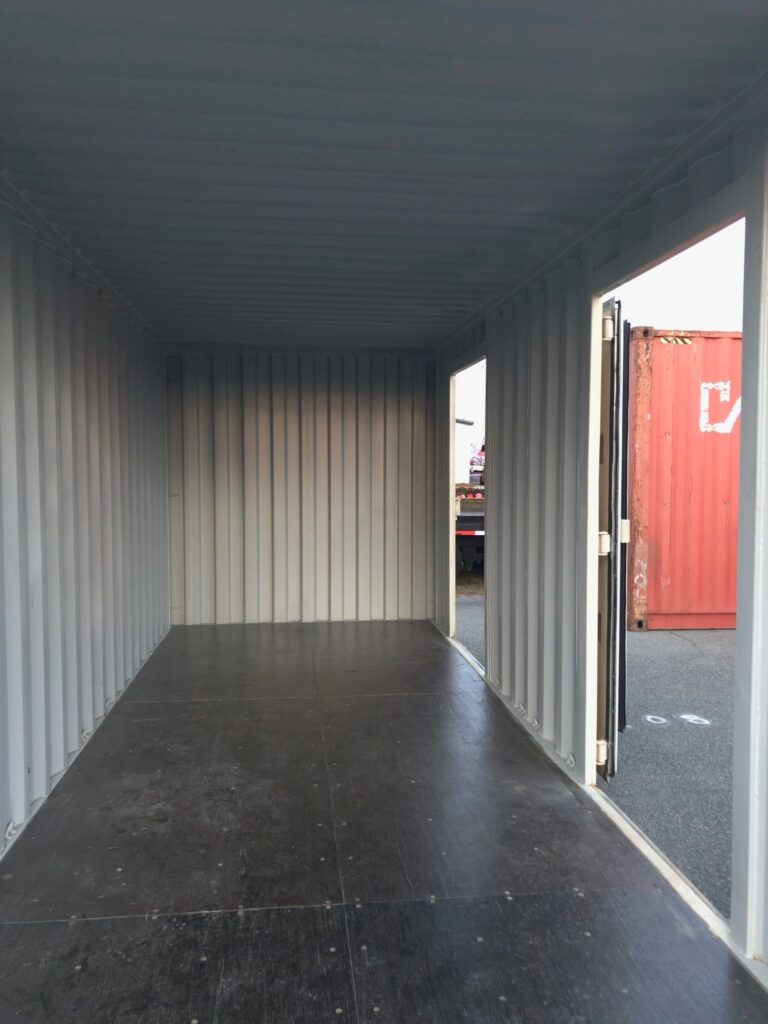 The interior view of a modified multi door shipping container looking out through multiple open side doors, providing extra access points for workflow efficiency.